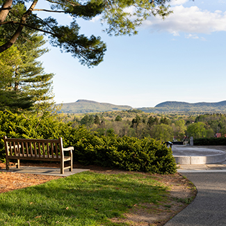 A photo of a bench overlooking the Mount Holyoke range