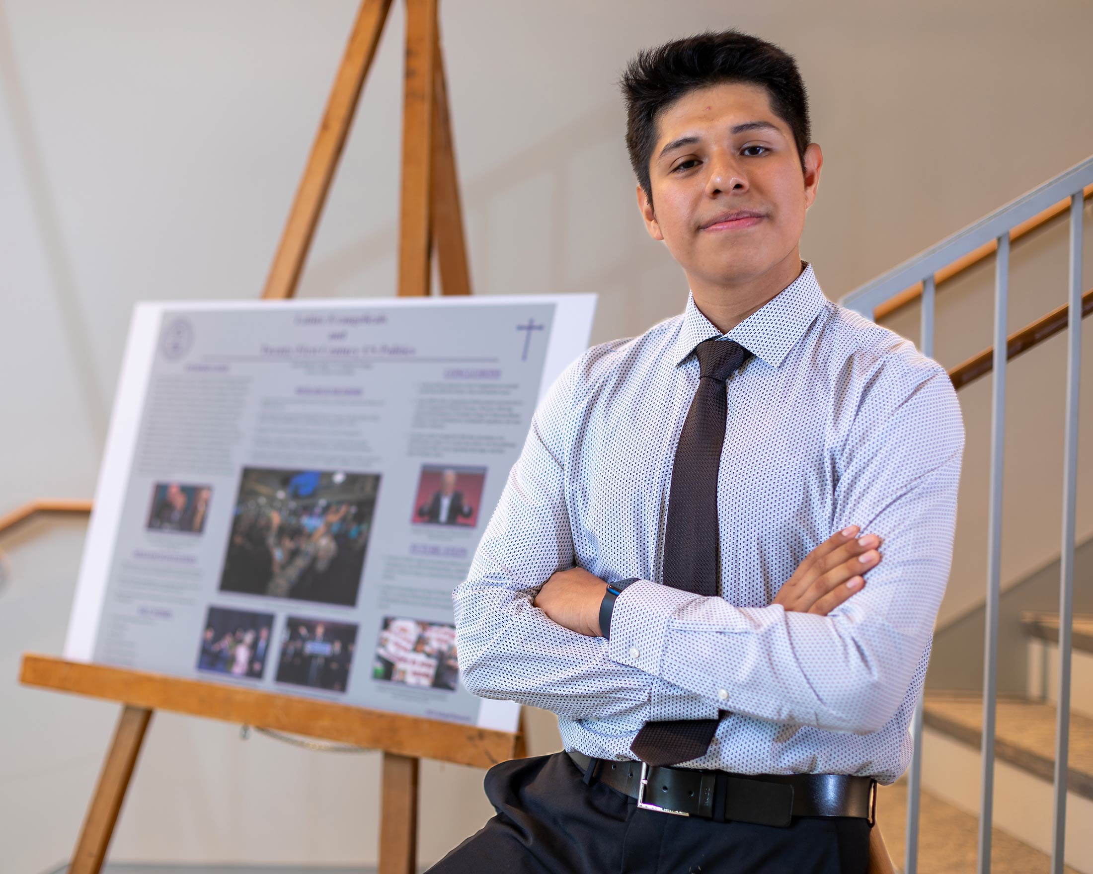 Jesus Ramirez Tapia poses in front of a poster about his research on Latinx Evangelicals and Twenty-First Century US Politics.