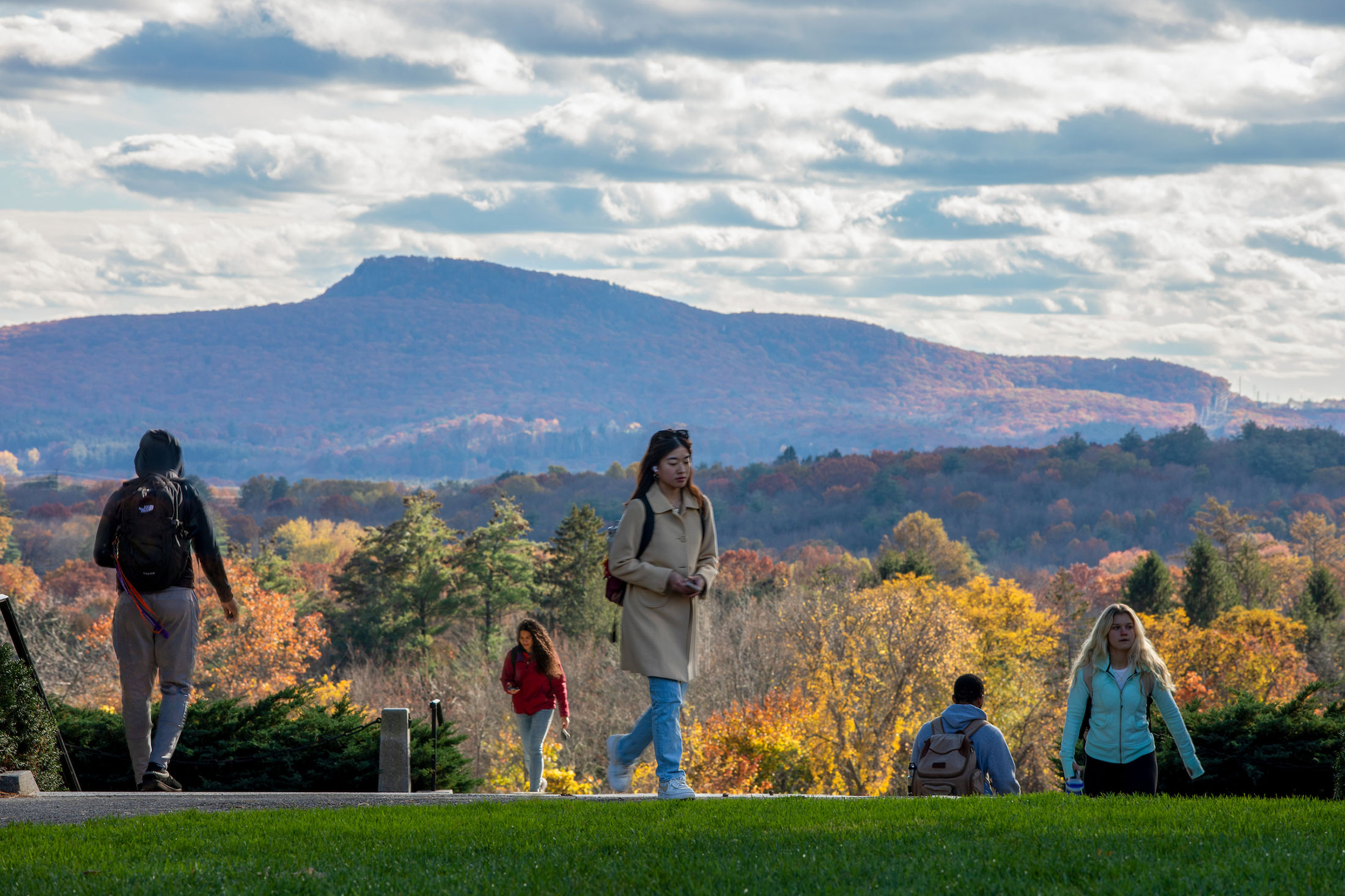 Students walking on campus with the Mt. Holyoke Range visible behind them.