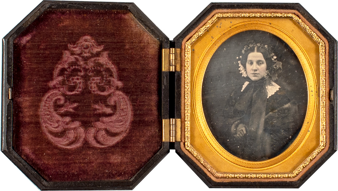 An antique picture frame with a photo of a woman inside the frame
