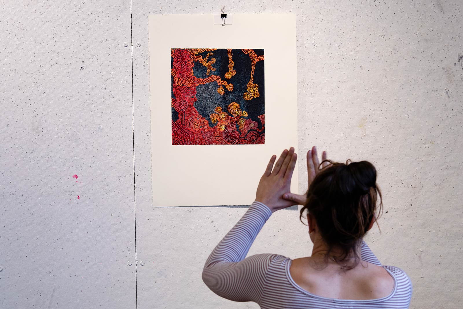 A student examines a print hanging on the wall