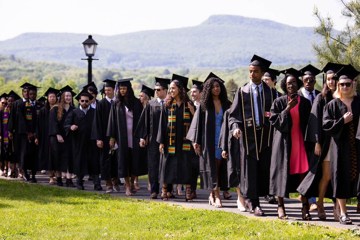 Amherst College graduates processing to the ceremony; Mt Holyoke range showing in the distance