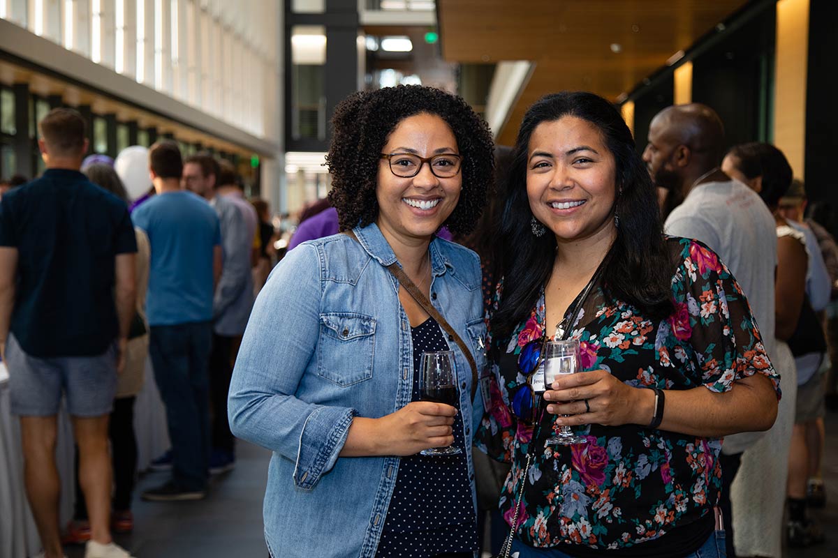 Two alumni at  standing side by side at a reception in the Science Center