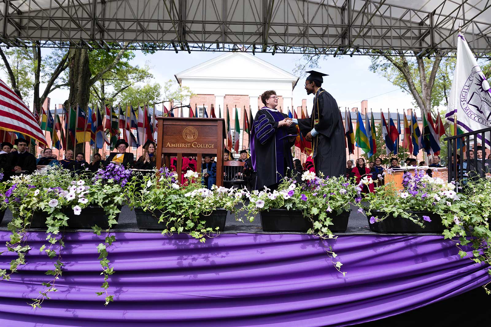President Biddy Martin shaking hands with a graduate