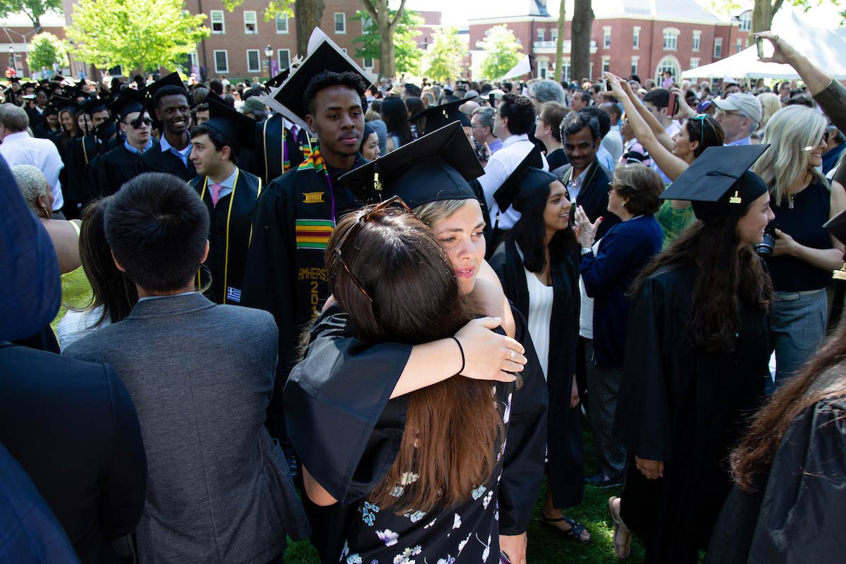 An Amherst College graduate hugs a well-wisher