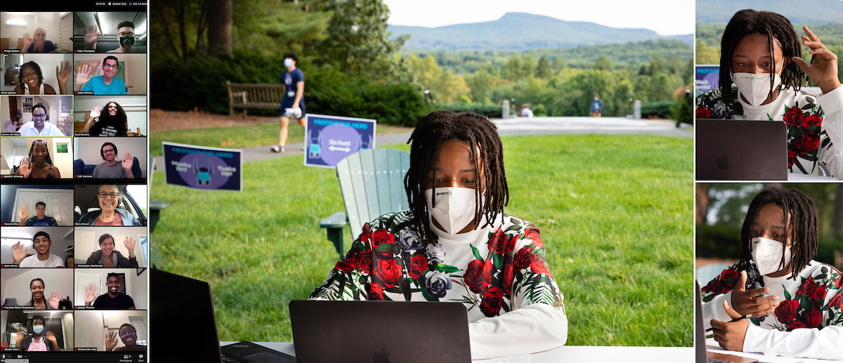 a student sitting on the main quad participates in a zoom class with a view of the holyoke range in the background