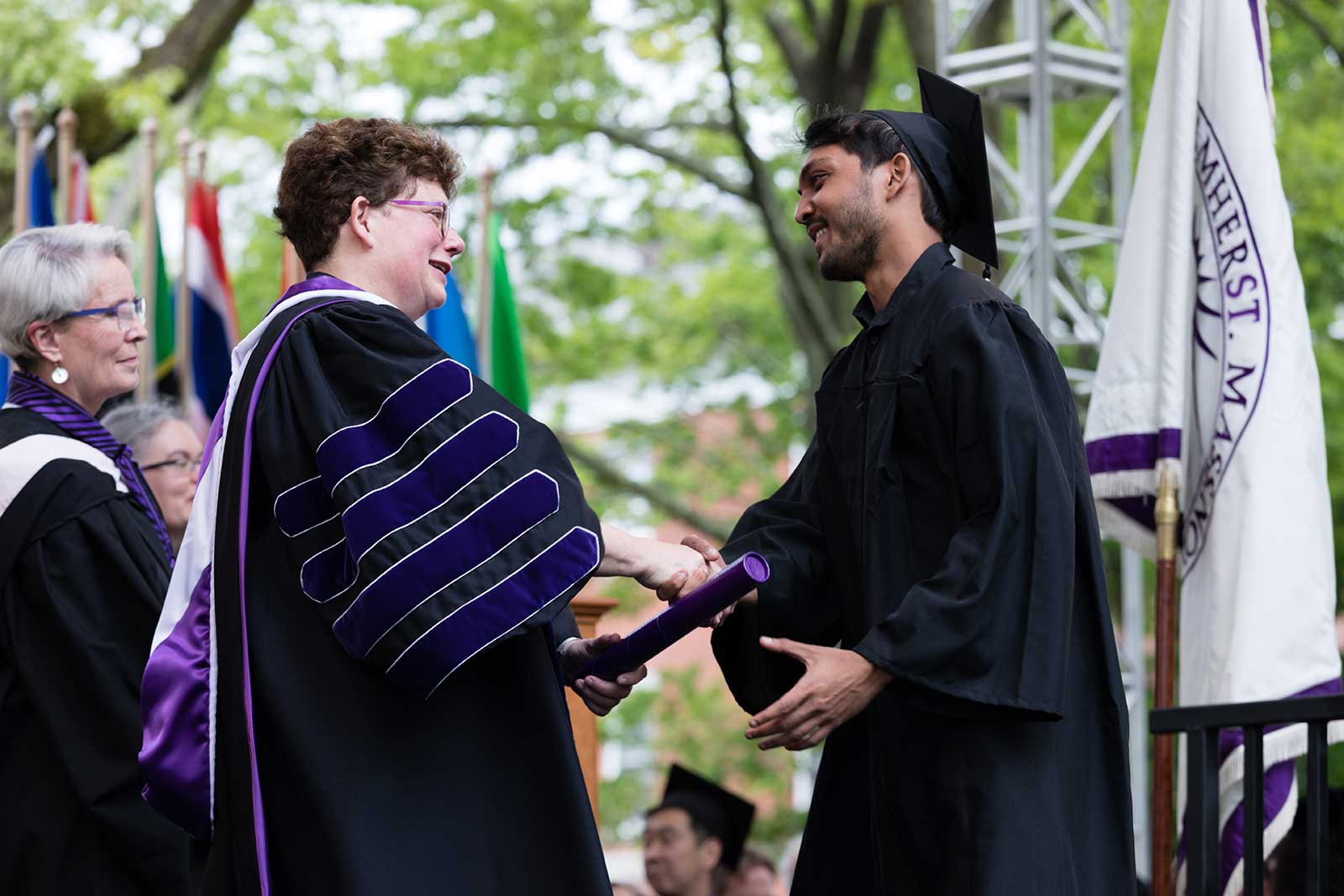 President Martin shaking hands with a graduate