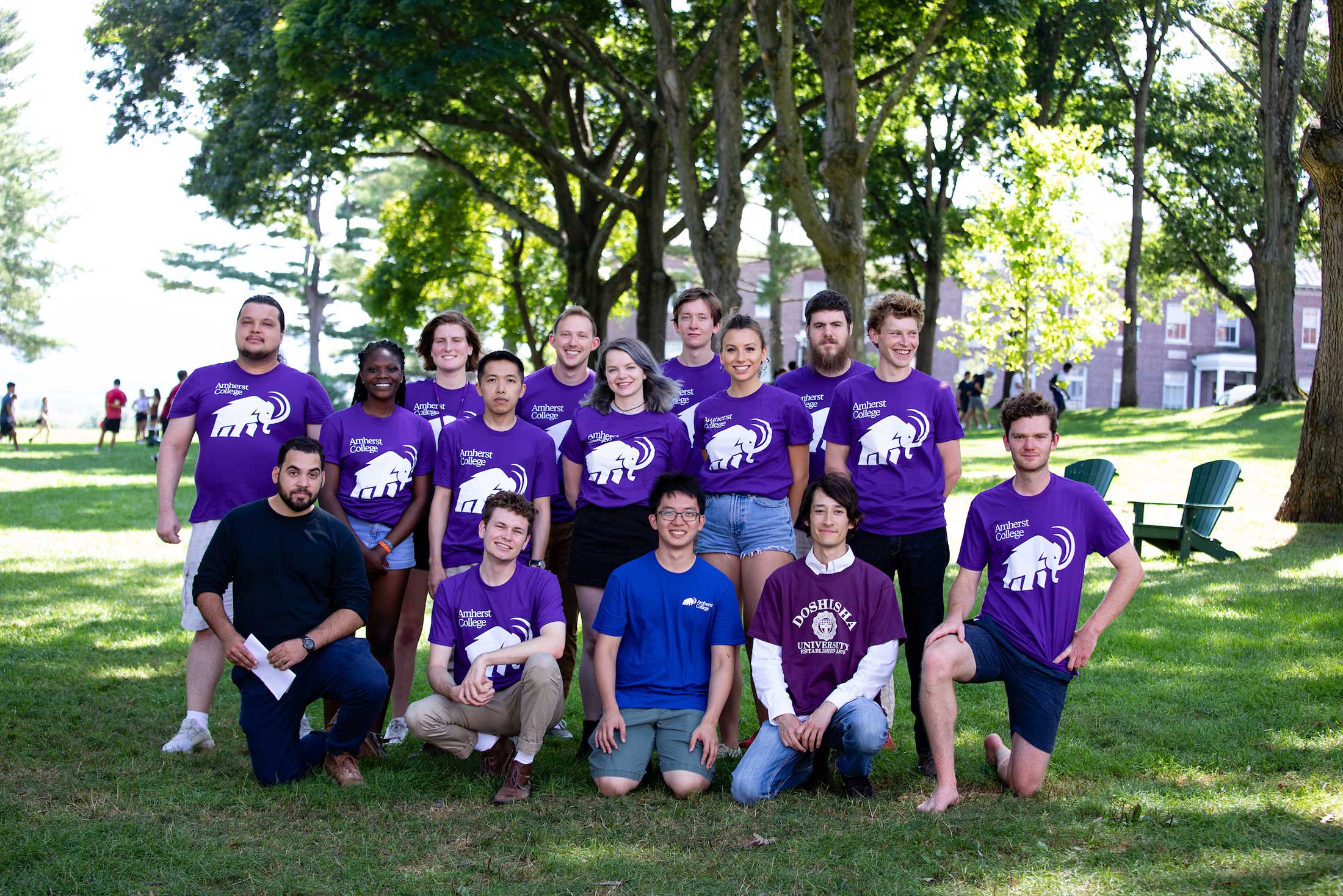A group of transfer students -- most of them wearing purple mammoth tshirts -- pose together on the academic quad.