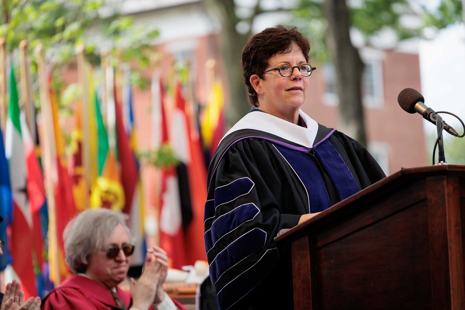 President Biddy Martin stands behind the podium on stage during commencement.