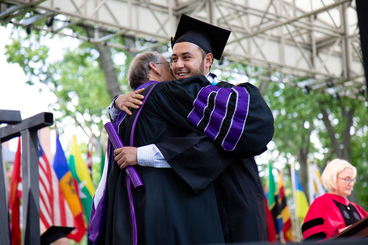 A faculty member congratulates a graduate