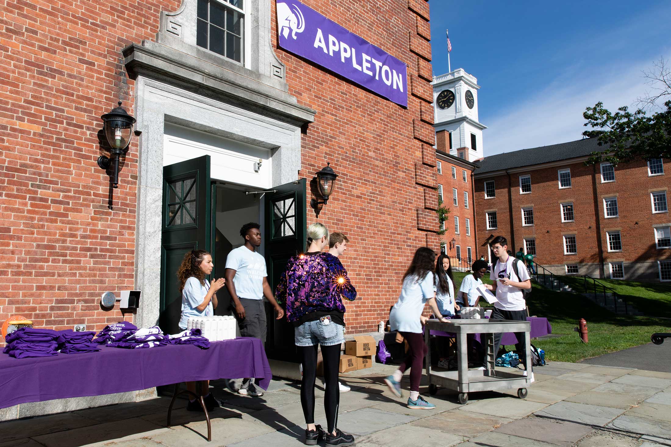 Amherst College staff greet new students arriving in front of Appleton Hall