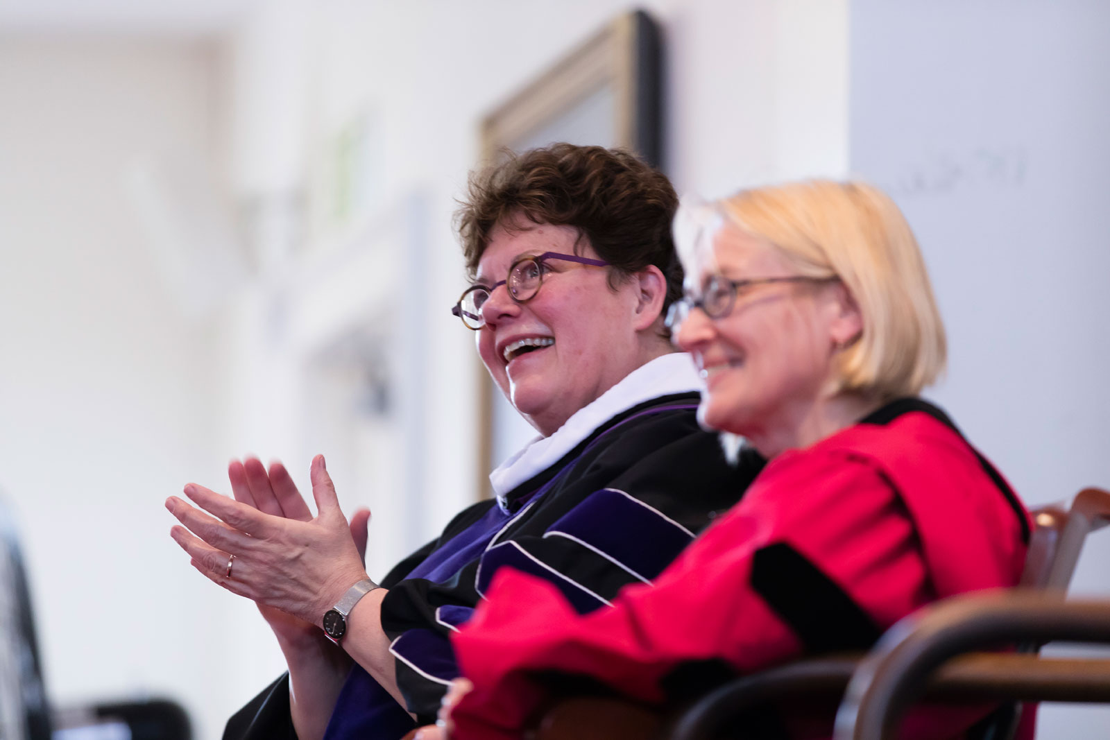 Seated on stage, President Biddy Martin and Dean of the Faculty Catherine Epstein applaud