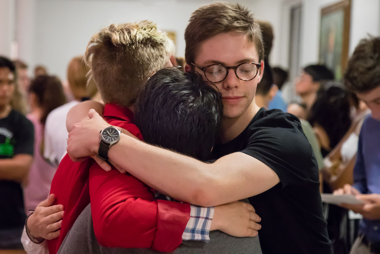 Three students hug