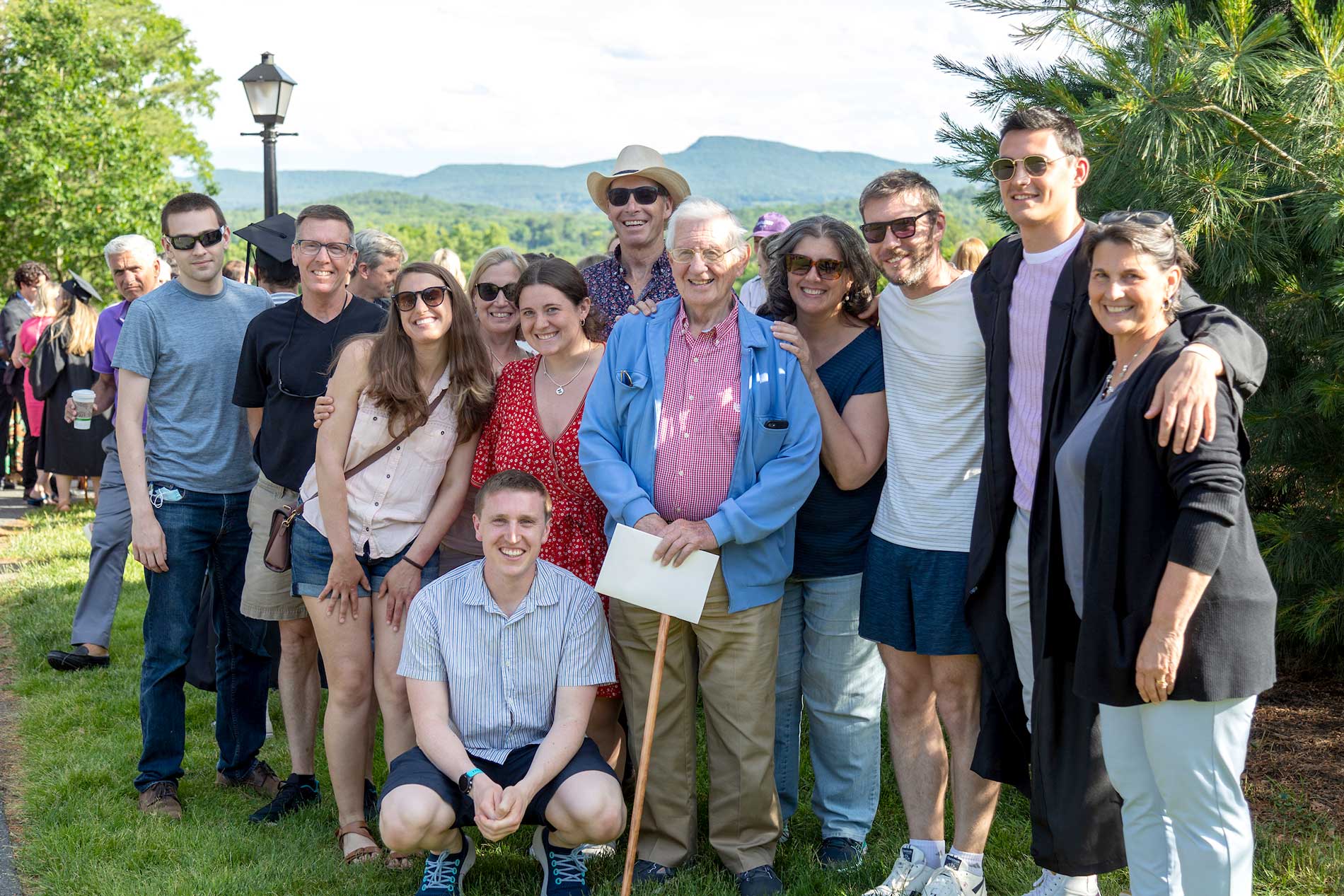 A large family poses for a portrait with the Mt Holyoke range in the background..