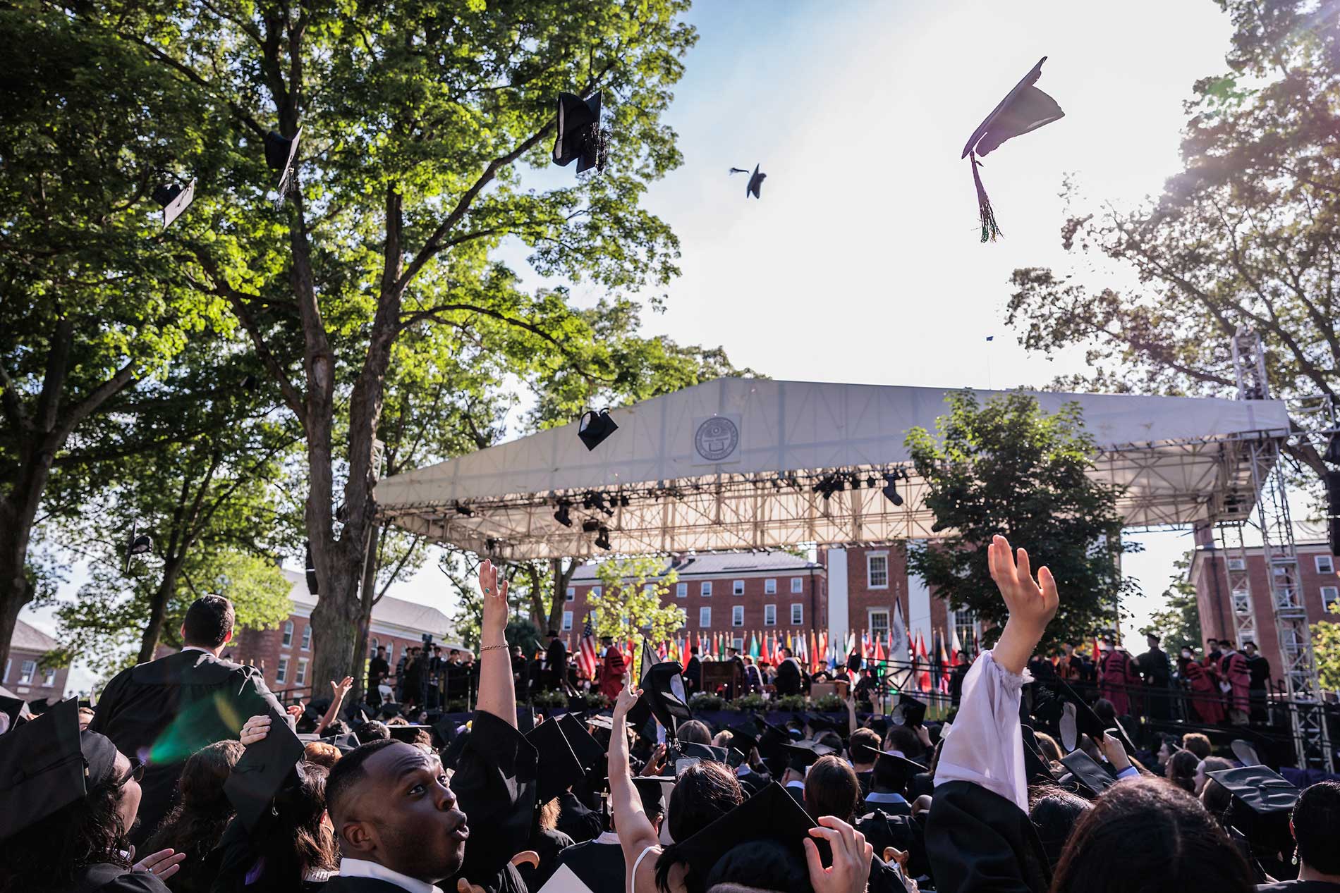 Graduates toss their caps in the airs.