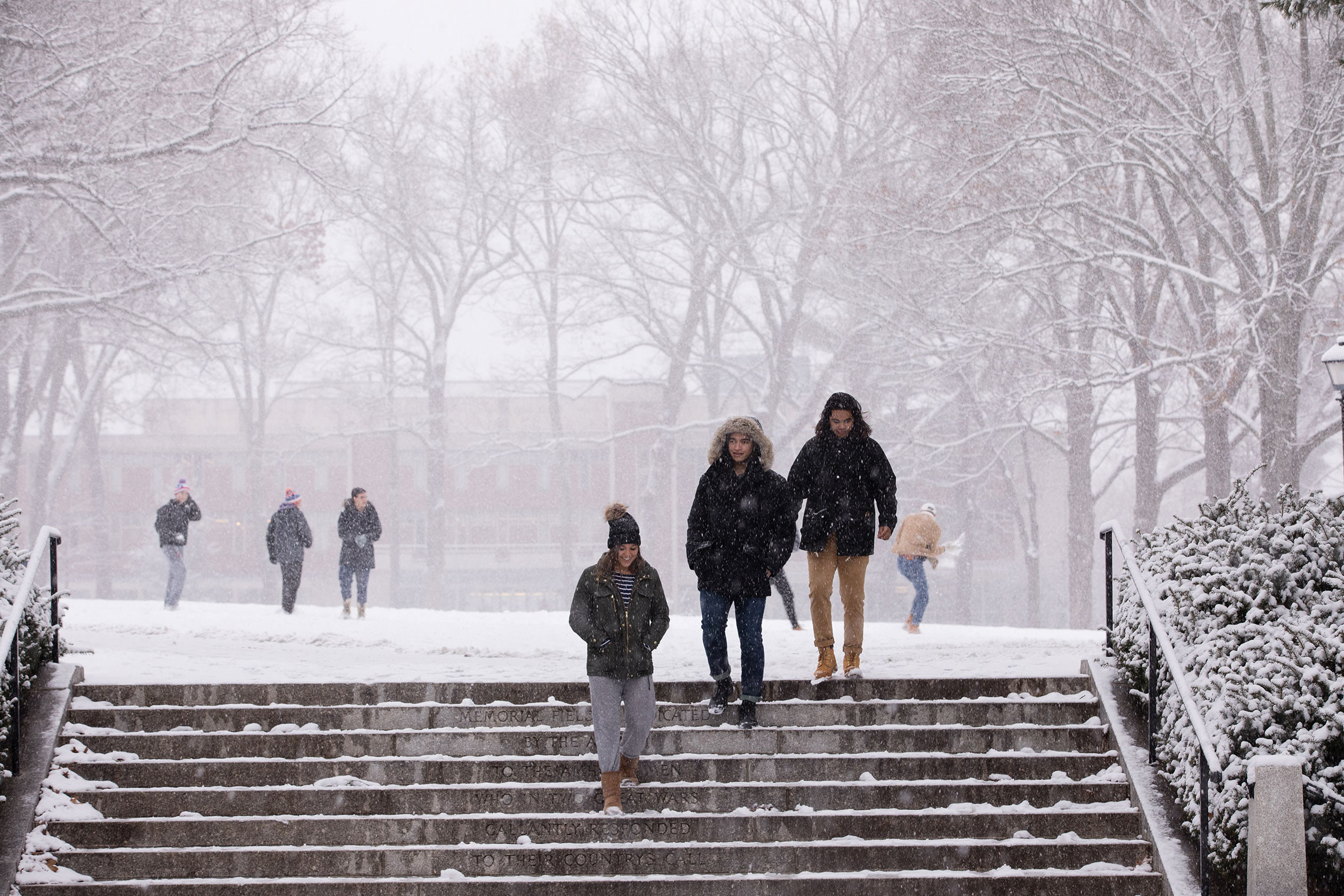 Student walking across campus during the first snowfall of 2017.