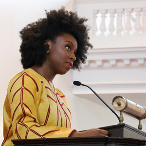 Chimamanda Ngozi Adichie speaking at a podium in Johnson Chapel