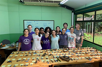 A group of students standing behind a table with biology samples