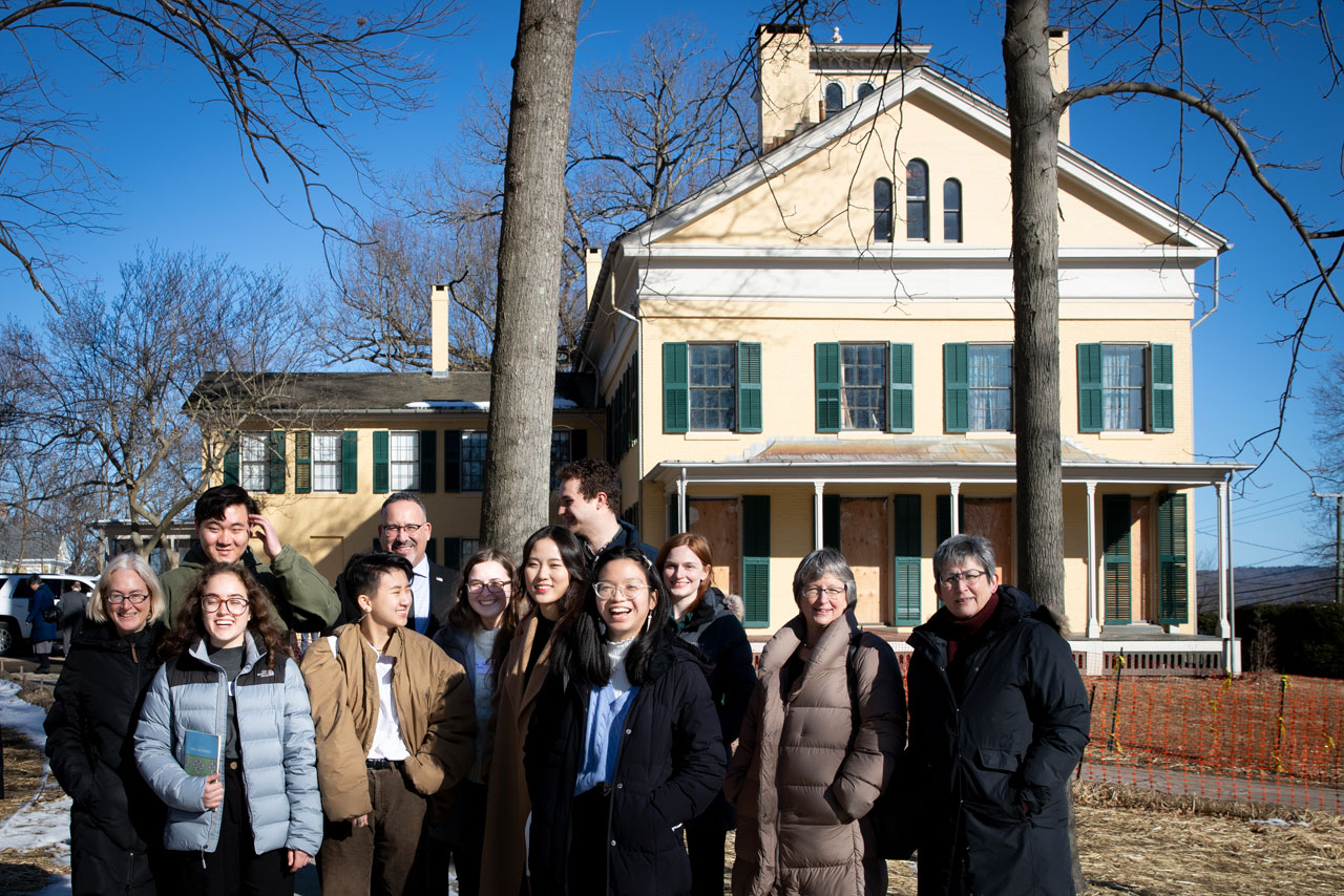 Miguel Cardona poses with students, faculty and others outside the Emily Dickinson Museum