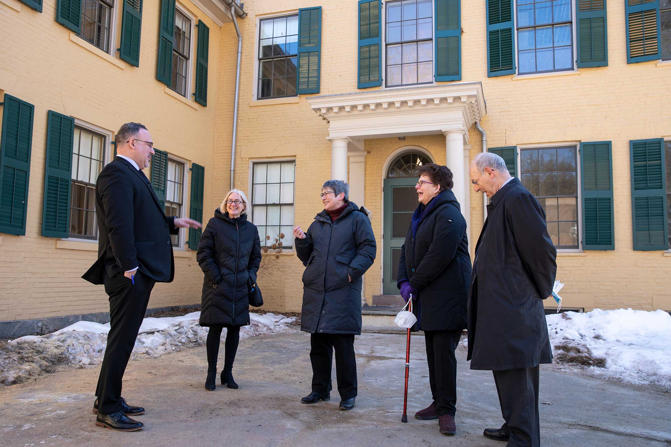 Miguel Cardona, Catherine Epstein, Jane Wald, and President Biddy Martin stand in front of  the Emily Dickinson museum.