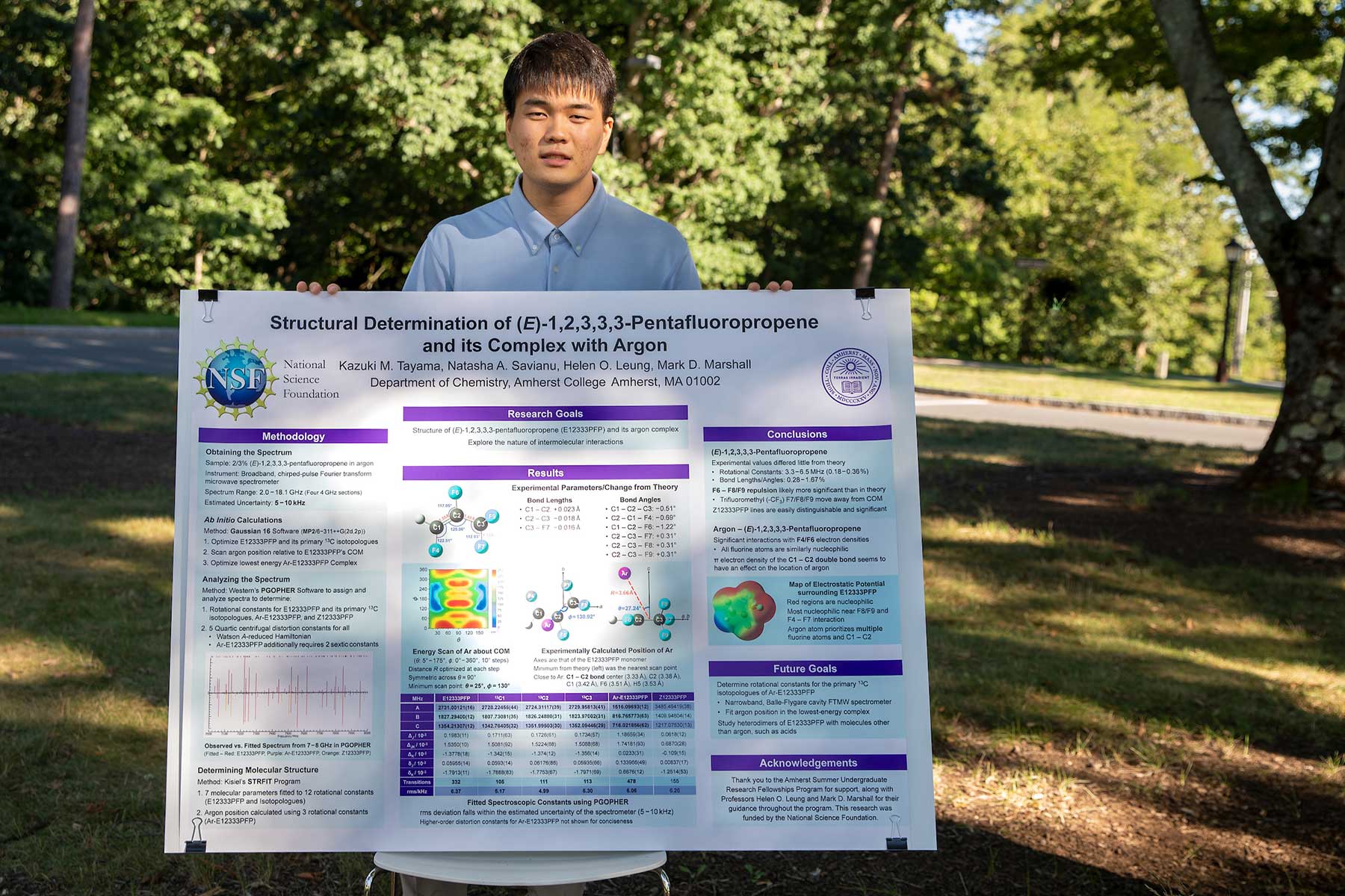 Kazuki Tayama '24 holds a poster on his summer research.