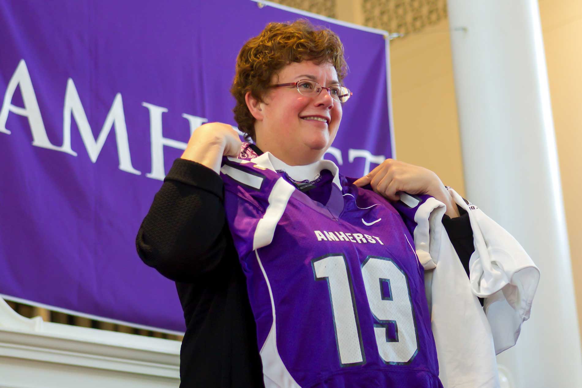 President Martin hold a number 19 jersey, gifted to her at her inauguration.