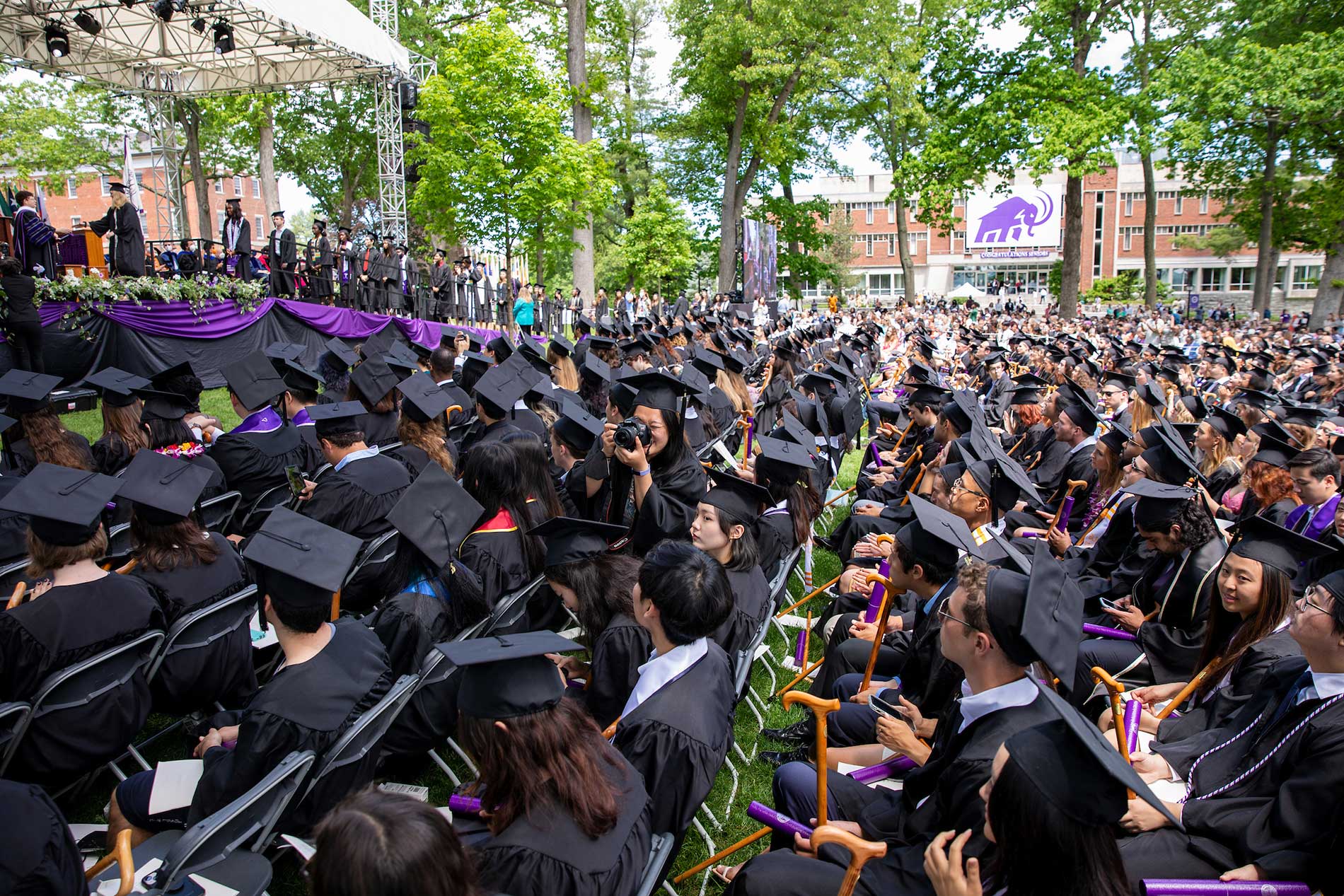 Amherst College graduates sit in the audience, awaiting the awarding of degrees.