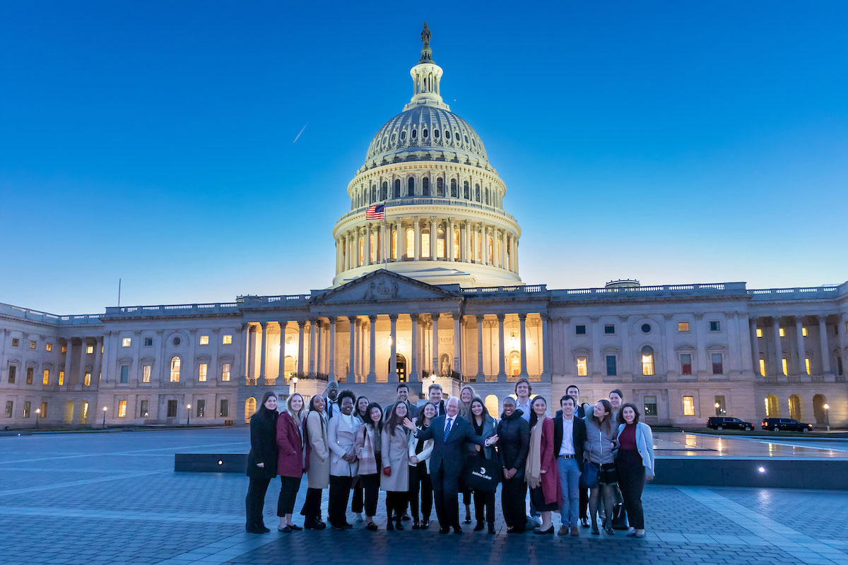 Career Trek participants pose outside of the Capitol Building at dusk.
