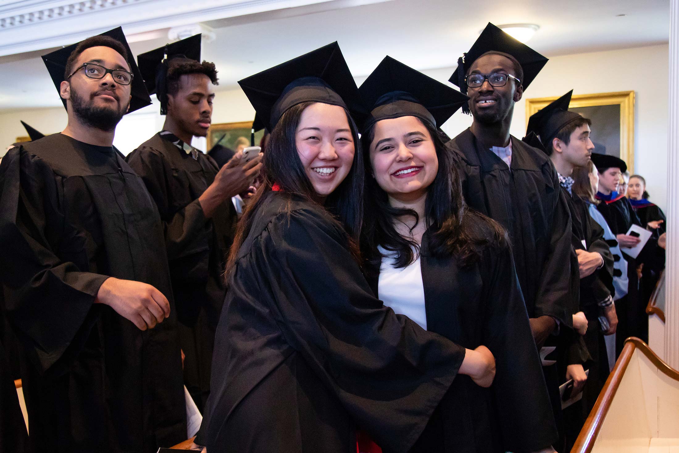 Smiling students wearing graduation gowns