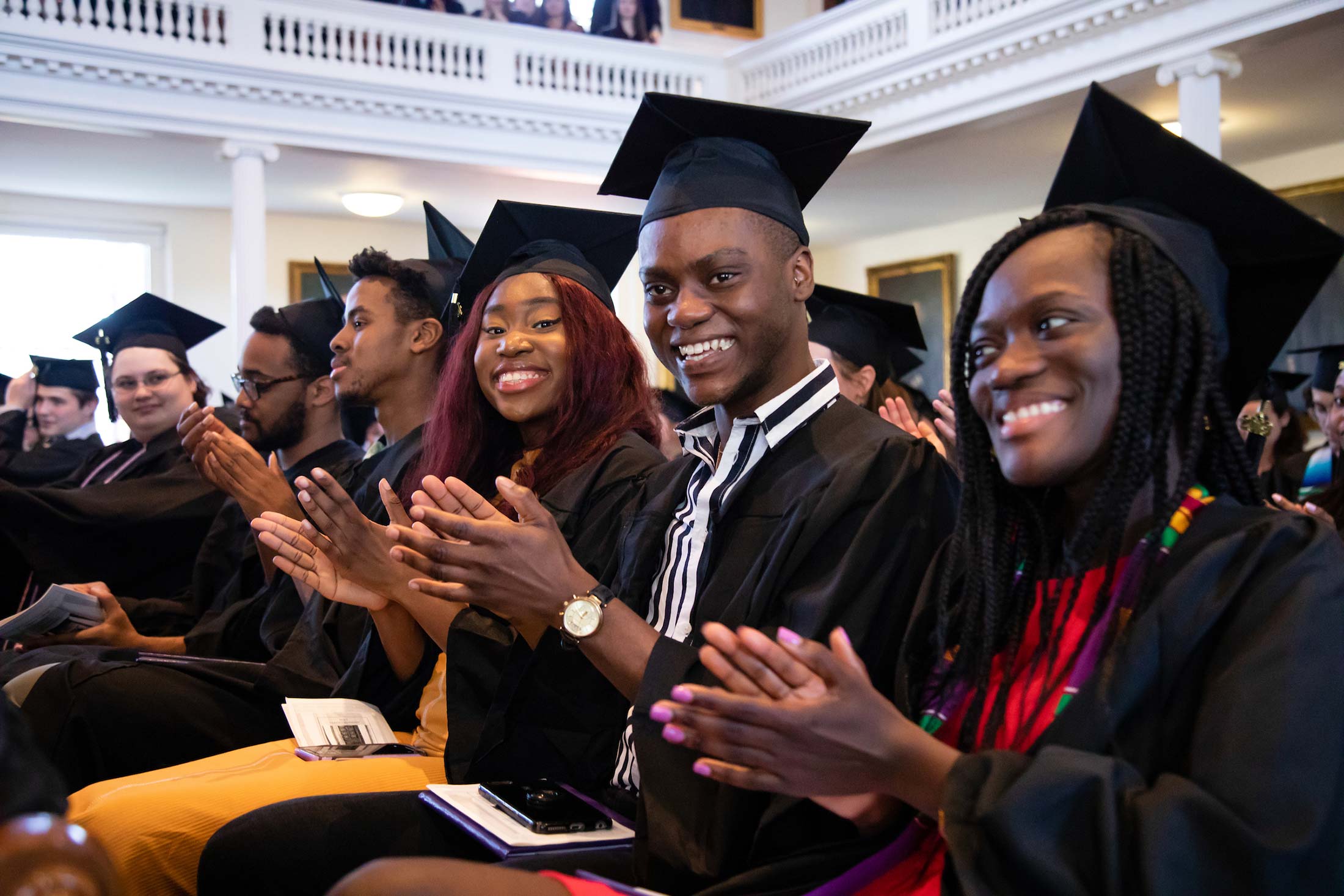 Student clapping during Senior Awards Assembly in Johnson Chapel at Amherst College