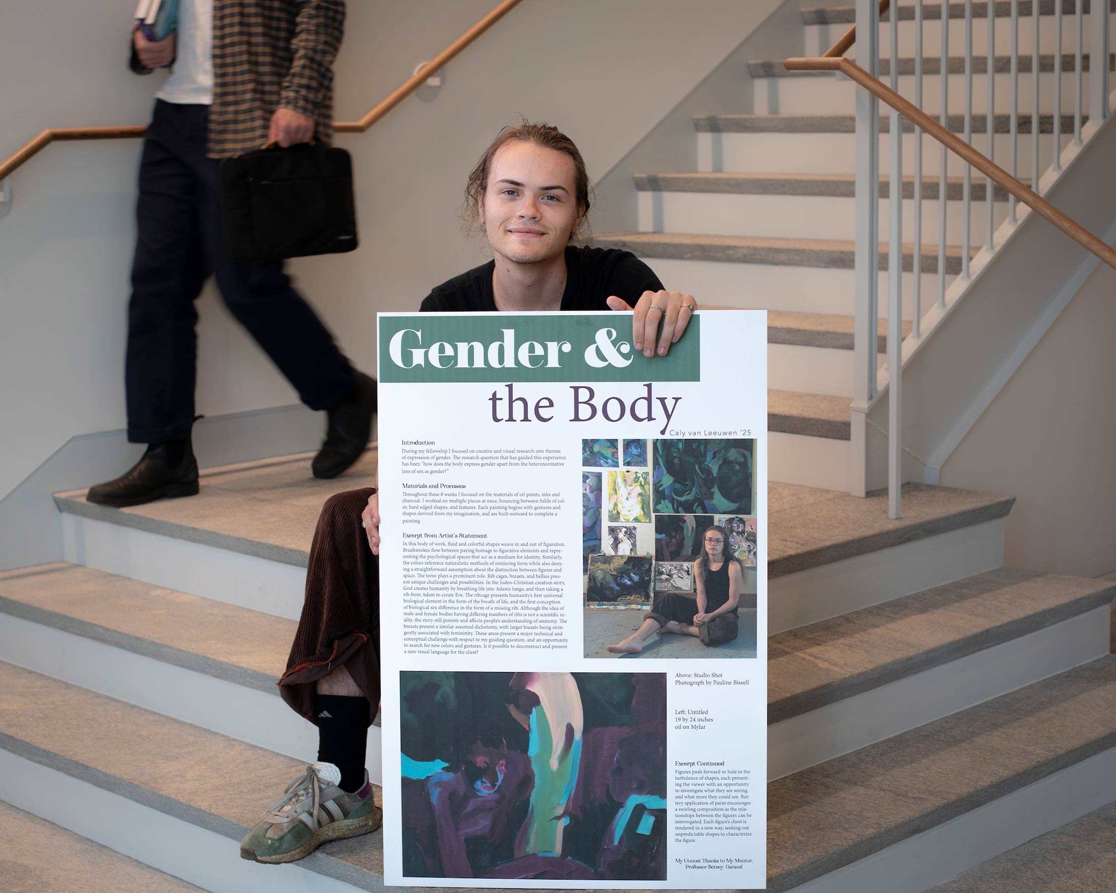 Caly Van Leeuwen holds his research poster titled Gender and the Body.