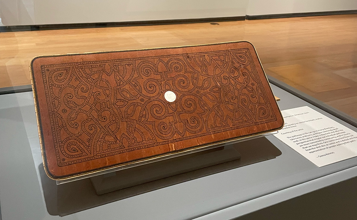 An intricatly carved piece of bark shaped in a rectangle