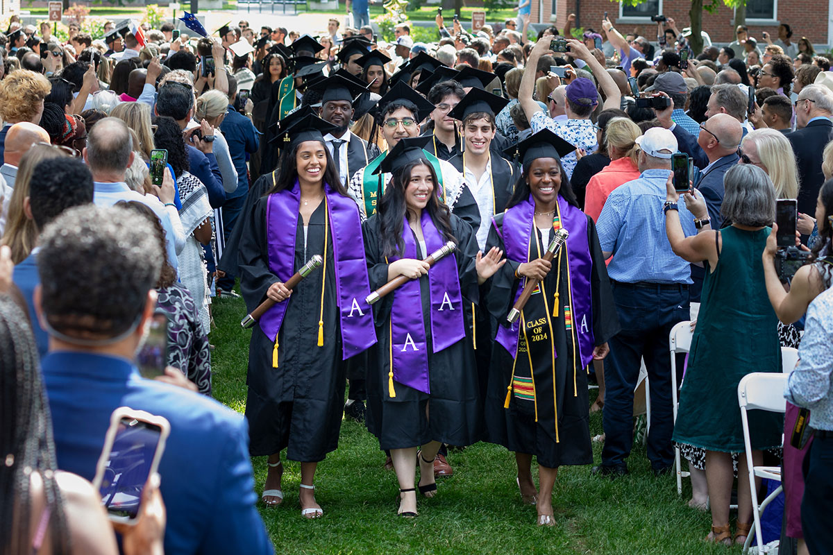Three student marshals lead the procession of graduates during the Commencement ceremony at Amherst College.