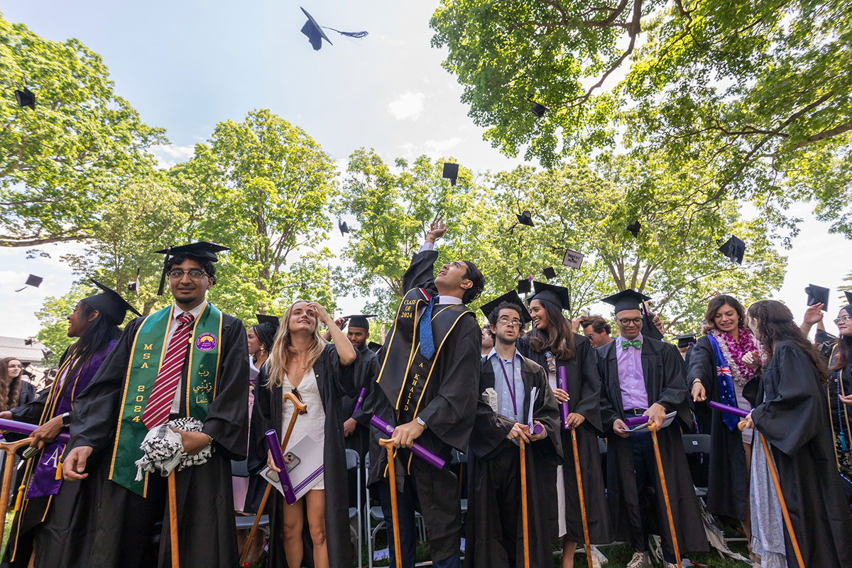 Students toss their graduation caps at the end of the Commencement ceremony.