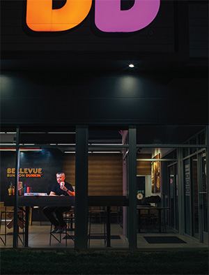 A man sitting in a dark coffee shop at night