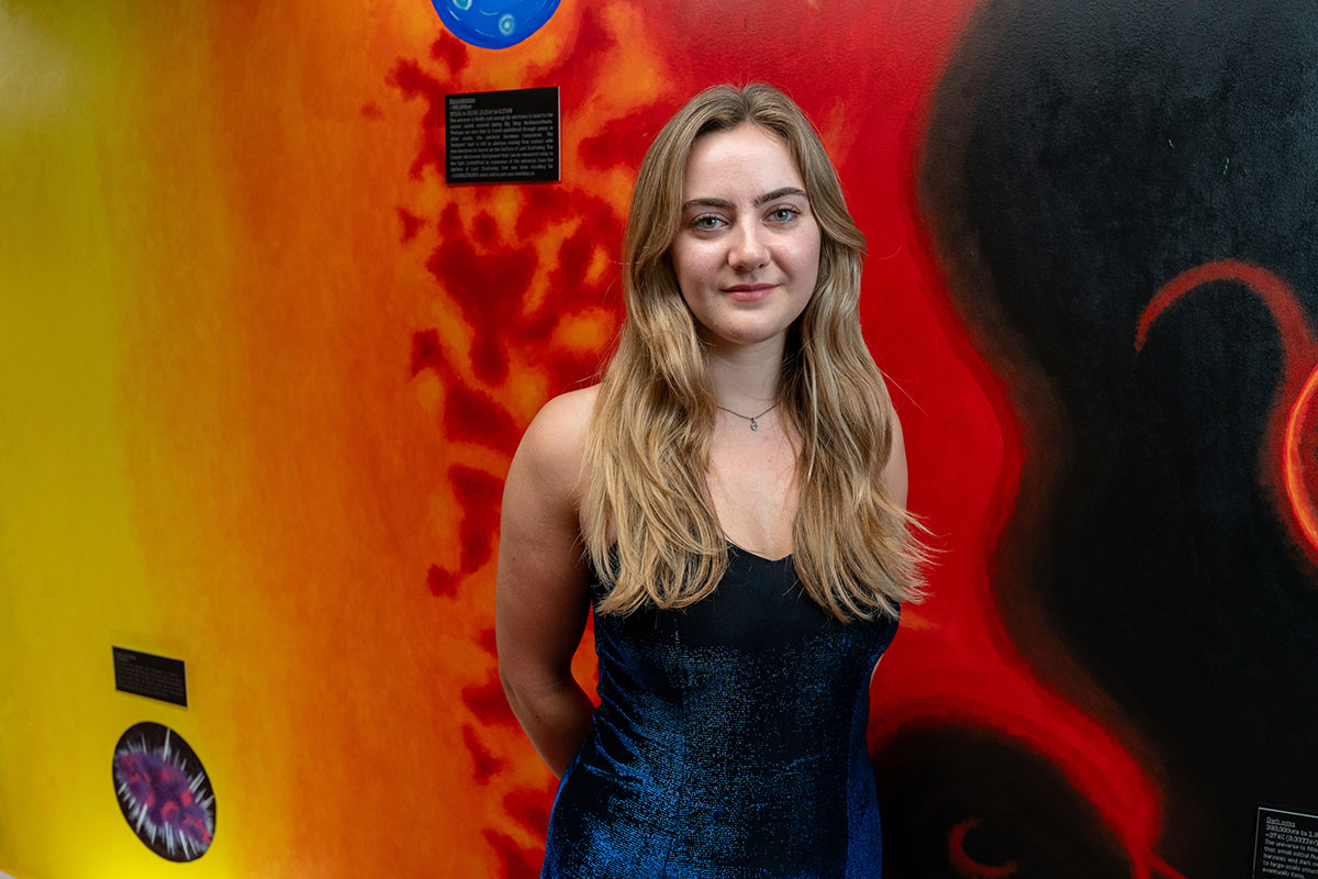 Eliza Hillenkamp ’24 poses in front of her mural.