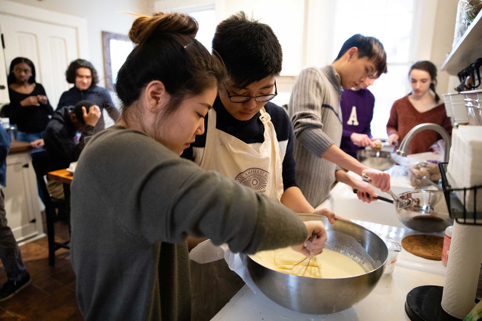 Students mixing and stirring ingredients in a bowl