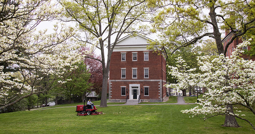 Staff member mowing the lawn on the Amherst College campus