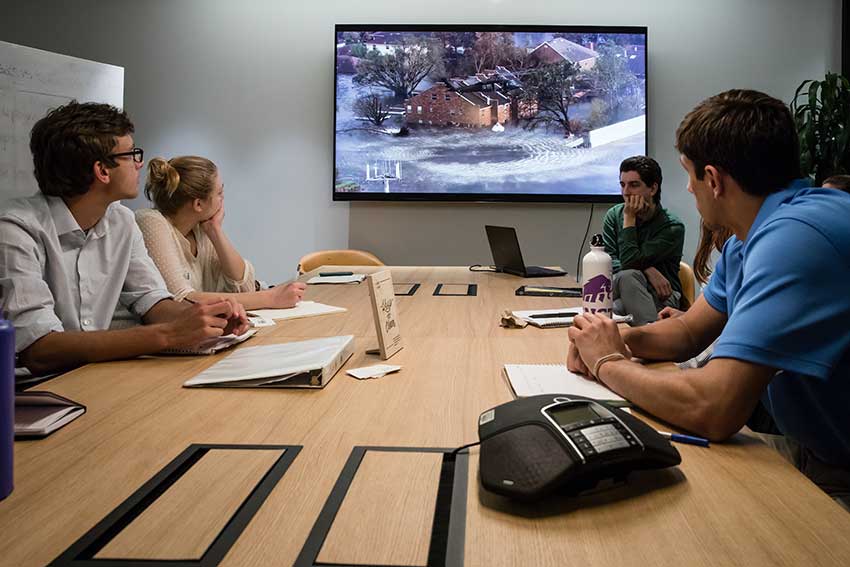 Amherst students and instructors sitting around a conference table 