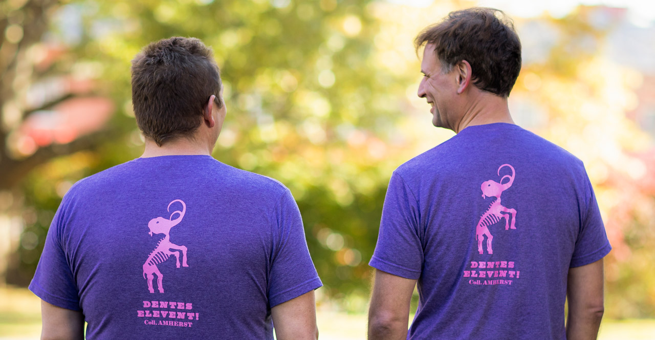 two professors wear the same t-shirt with a mammoth skeleton on the back