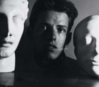 James Merrill ’47 posed between a scultpure of a Hermes and a life mask of Keats.