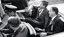 Kennedy riding in a motorcade along South Pleasant Street with Amherst President Calvin Plimpton ’39