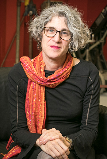 A woman with gray hair, glasses and a scarf