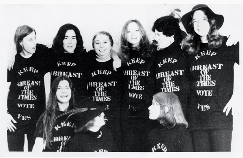 Faculty women in 1974 wearing "Keep Abreast of the Times" T-shirts