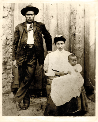 Ned Cobb posed by wood door, with wife Viola and son Andrew