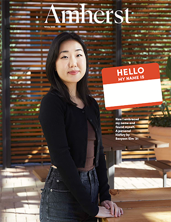 Magazine cover showing a woman standing behind a desk with a sticker that says Hello my name is.