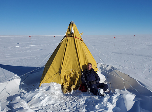 A person sitting outside a tent in Antartica