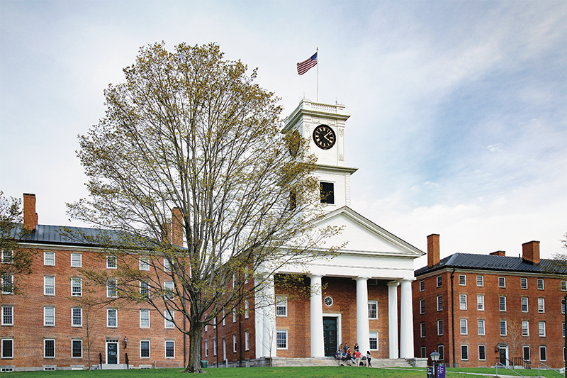 A bare tree in front of Johnson Chapel under a bright cloudy sky
