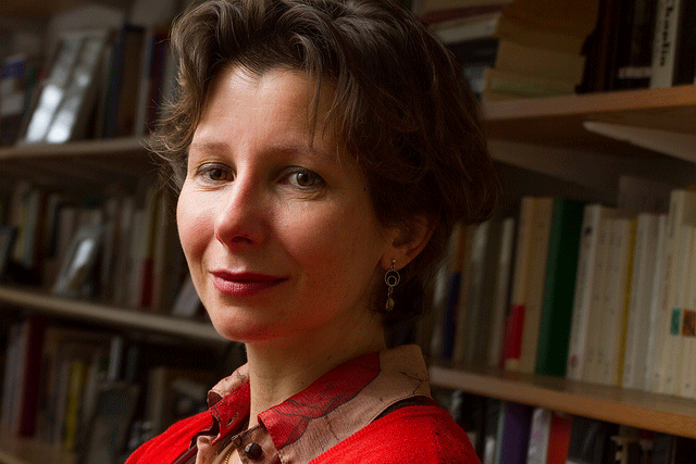 Close-up of Laure Katsaros in front of a bookshelf