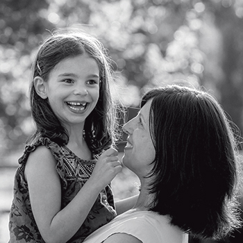 A black and white photo of a mother and daughter hugging and smiling
